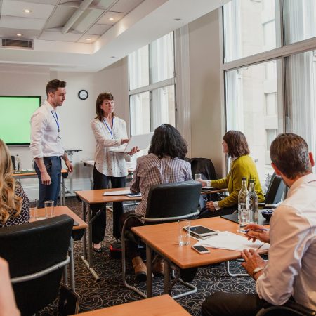 Mature female adult and her coworker answering questions.