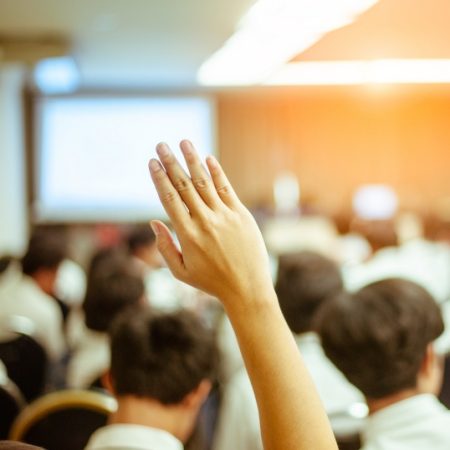 businessman raising hand during seminar. Businessman Raising Hand Up at a Conference to answer a question.