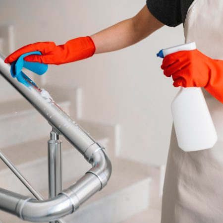 Close-up woman cleaning railing of stairs
